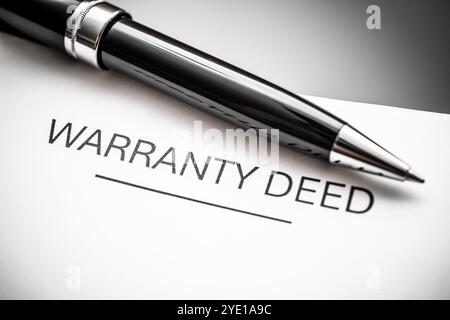 Nahaufnahme eines Garantieurkunden mit einem Stift, das rechtliche Vereinbarungen, Eigentumsrechte und Immobilientransaktionen für Käufer und se symbolisiert Stockfoto