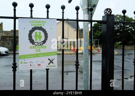 Anti-Raucher-Schild an einem schmiedeeisernen Zaun im Athenry Park in Athenry, County Galway, Irland; Kampagne „Not around US“, in der das Rauchen und Verdampfen verboten ist. Stockfoto