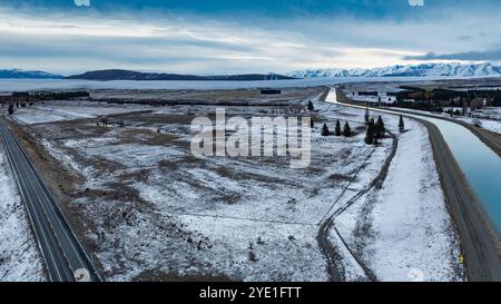 Aus der Vogelperspektive auf die Alpenautobahn und den Wasserkraftkanal im Schnee Stockfoto