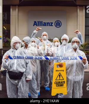 London, Großbritannien. Oktober 2024. Aktivisten in Gefahrenanzügen halten ein „Climate Crime Scene“-Band vor den Büros der Allianz, während die Extinction Rebellion drei Tage lang Proteste in der City of London, dem Finanzviertel der Hauptstadt, anfängt, Versicherungsgesellschaften aufzufordern, die Versicherung von Projekten mit fossilen Brennstoffen einzustellen. (Foto: Vuk Valcic/SOPA Images/SIPA USA) Credit: SIPA USA/Alamy Live News Stockfoto