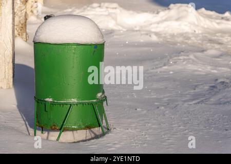 Eine schneebedeckte Mülltonne an einer ländlichen Winterstation Stockfoto