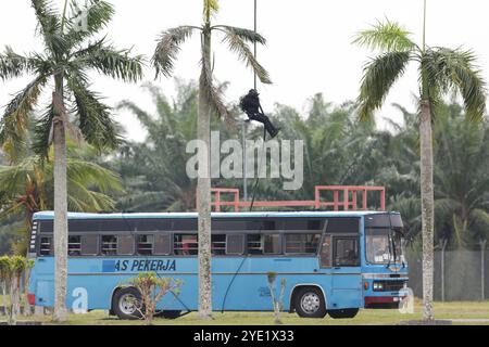 Selangor, Malaysia. Oktober 2024. Ein Mitglied der Royal Malaysian Air Force Special Forces, besser bekannt als PASKAU, seilt sich während einer Terrorismusbekämpfung auf der Luftwaffenbasis Jugra in einen simulierten Entführer-Bus ab. Die PASKAU ist eine Streitmacht mit Allwetterkampffähigkeiten an Land, zu Wasser und in der Luft, wobei die Funktionen und die Art der Spezialkräfte zur Terrorismusbekämpfung berücksichtigt werden. Sie sind gut ausgestattet und gut ausgebildet. Quelle: SOPA Images Limited/Alamy Live News Stockfoto