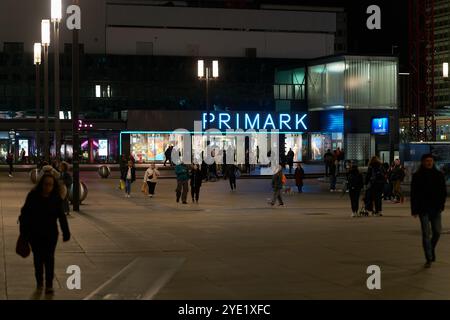 Straßenszene mit einigen Leuten im Primark am Alexanderplatz in Berlin am Abend Stockfoto