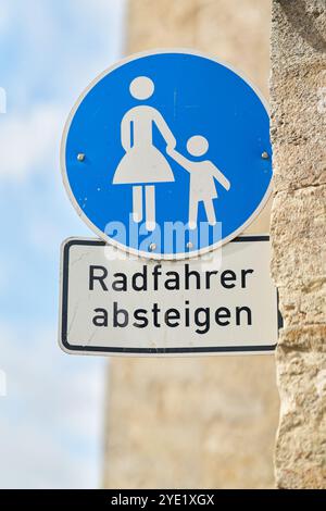 In einer Fußgängerzone mit der deutschen Aufschrift Radfahrer absteigen. Übersetzung: Radfahrer steigen ab Stockfoto