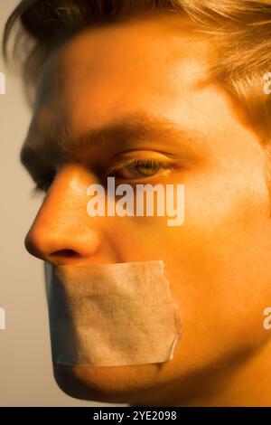 Attraktiver Mann, blonder Mund, das Konzept der Sprachfreiheit Stockfoto