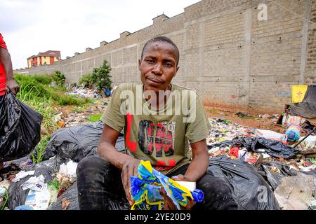 Ein Müllsammler wartet auf der Kibera Wanakolo Deponie. Laut der Weltgesundheitsorganisation ist Depression eine häufige psychische Störung, die depressive Stimmung, Verlust der Freude und Interesse an Aktivitäten für lange Zeiträume beinhaltet. Die Mülldeponie Wanakolo ist eine kleine Mülldeponie in Kibera Slums. Hier sind über hundert depressive und psychisch gestörte Müllsammler untergebracht, einige mit Hochschulabschluss und -Fähigkeiten, die von der Mülldeponie als Heim und als Einkommensquelle abhängen, wo sie die Abfälle entsorgen, nachdem sie sie aus den Wohnhäusern und Geschäftsräumen in der Nachbarschaft gesammelt und später abgesaugt haben Stockfoto