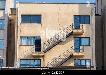 Symmetrie in der Alten Architektur: Fenster, Treppen und Metallgeländer an einem sonnigen Tag Stockfoto