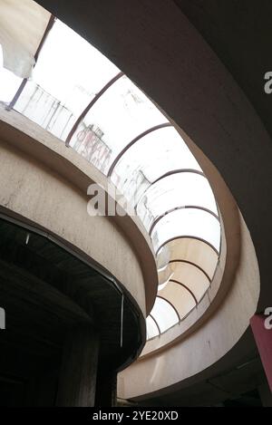 Vergessene Eleganz: Geschwungener Glasrahmen im Verfall, flacher Blick auf ein verlassenes Gebäude im Inneren Stockfoto