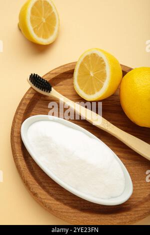 Zahnbürste mit Zitrone und Backpulver auf beigem Hintergrund. Draufsicht Stockfoto