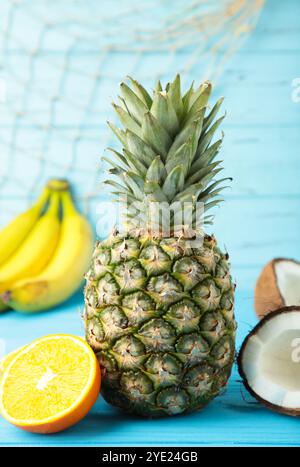 Tropische Früchte. Ananas, Kokos, Orange und Banane auf blauem Hintergrund. Draufsicht Stockfoto