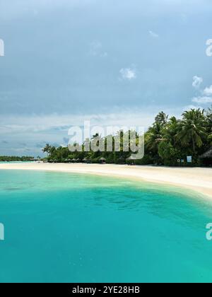 Entdecken Sie die Ruhe an diesem unberührten Strand, wo türkisfarbenes Wasser auf weißen Sand und üppige Palmen trifft. Ein perfekter Zufluchtsort in das tropische Paradies der Natur Stockfoto