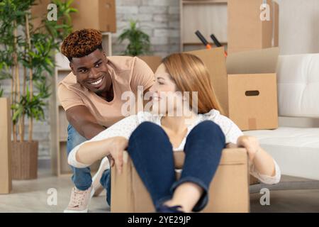 Glückliches Paar, das Spaß beim Auspacken hat, lacht Stockfoto