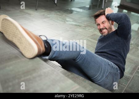 Geschäftsmann in Anzügen, der bewusstlos auf dem Boden liegt Stockfoto