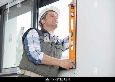 Worker prüft das Niveau eines Fensters Stockfoto