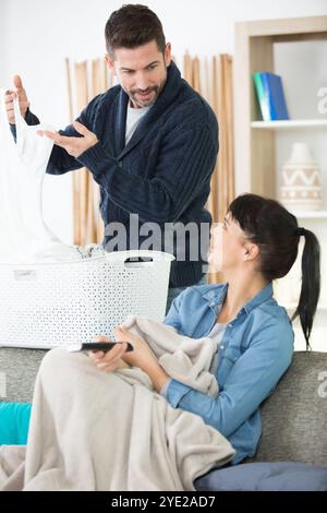 Ein Mann arbeitet, während er auf einer Couch faul war Stockfoto