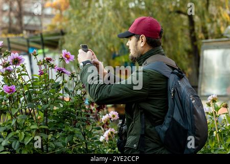 Die Hände des Mannes mit Handy machen Fotos von Blumen. Hochwertige Fotos Stockfoto