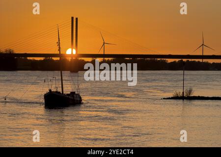 Sonnenuntergang über dem Rhein Niederrhein, links im Vordergrund verankertes historisches Schiff Aalschokker, im Hintergrund Westufer Stockfoto