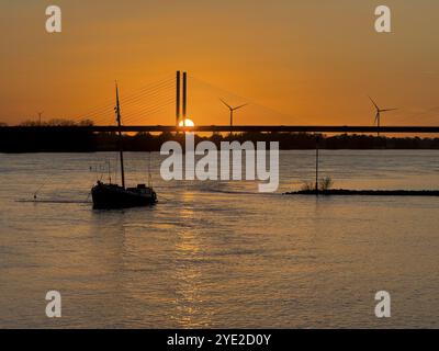 Sonnenuntergang über dem Rhein Niederrhein, links im Vordergrund verankertes historisches Schiff Aalschokker, im Hintergrund Westufer Stockfoto