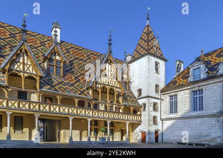 Hospices de Beaune oder Hotel-Dieu de Beaune ist eine ehemalige karitative Almshouse in Beaune, Frankreich. Innenhof, Innenfassade mit polychromem Dach Stockfoto