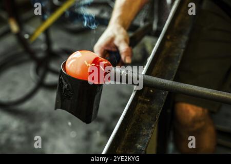 Der Mensch benutzt ein Holzwerkzeug, um die Form seiner Laterne zu Formen. Nahaufnahme mit Rauch und Bewegung Stockfoto