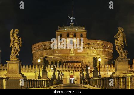 Blick auf die Engelskulptur auf der Ponte Sant'Angelo und das Schloss des Heiligen Engels in Rom. Abends Stockfoto