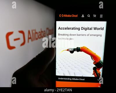 Deutschland. Juni 2024. In dieser Fotoabbildung hält eine Person ein Mobiltelefon mit der Webseite des chinesischen Computerunternehmens Alibaba Cloud vor dem Geschäftslogo. Quelle: SOPA Images Limited/Alamy Live News Stockfoto