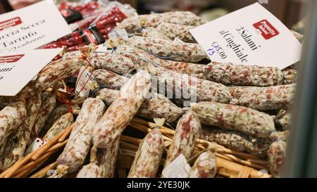 Besucher erkunden einen pulsierenden Stand voller Trüffelsalami beim Alba Truffle Festival in Italien. Die Veranstaltung bietet lokale Köstlichkeiten Stockfoto