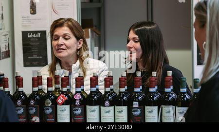 Beim Alba Truffle Festival nehmen die Teilnehmer an einer Weinprobe Teil und genießen lokale Sorten, während sie mit begeisterten Händlern über Aromen diskutieren. Stockfoto