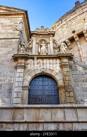 Avila, Spanien - 11. Februar 2023: Flacher Blick auf die Eingangstür an der Fassade des mittelalterlichen Domgebäudes. Stockfoto
