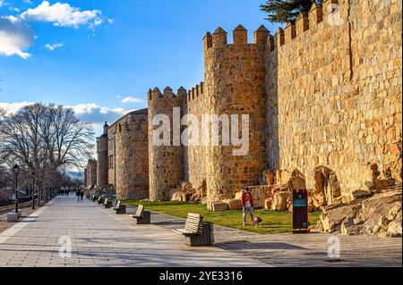 Avila, Spanien - 11. Februar 2023: Promenade entlang der mittelalterlichen Festungsmauern, ein berühmtes Wahrzeichen der Stadt. Stockfoto