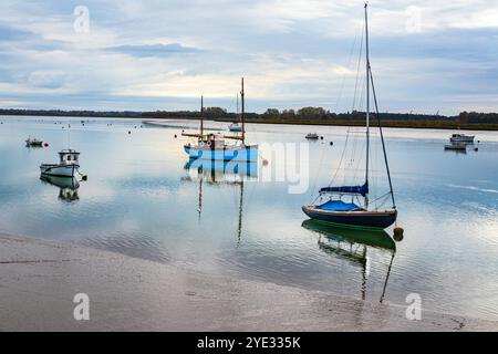 Bei Ebbe vertäute Boote auf dem Fluss Deben in der Nähe des Bawdsey Quay Woodbridge Suffolk mit Blick auf die Felixstowe Ferry England Stockfoto