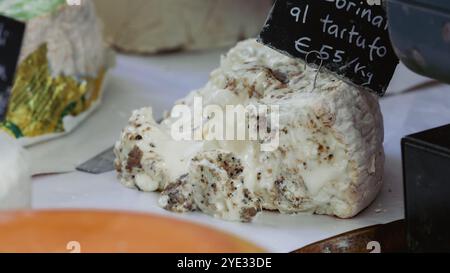 Auf einem Markt in Alba, Italien, wird ein cremiger Trüffelkäse präsentiert, der lokale kulinarische Traditionen und Angebote hervorhebt. Stockfoto