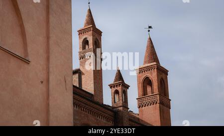 Die wunderschönen Türme eines alten Gebäudes in Alba, Italien, stehen vor einem klaren Himmel und zeigen ihr einzigartiges Design Stockfoto