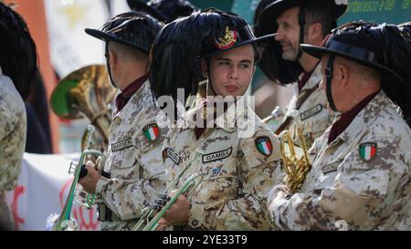 Eine Gruppe von Musikern, die in traditionellen Militäruniformen mit unverwechselbaren Hüten gekleidet sind, spielt während eines lebhaften Festivals in Alba, Italien, Blasinstrumente Stockfoto