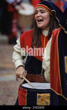 In Alba, Italien, findet eine lebhafte Feier statt, bei der ein temperamentvoller Schlagzeuger in lebendigen traditionellen Kleidern die Energie des Festivals einfängt Stockfoto