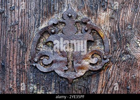 Avila, Spanien - 11. Februar 2023: Altes metallisches Schlüsselloch auf der hölzernen Oberfläche einer mittelalterlichen Tür. Stockfoto