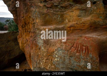 Agglestone Rock in Godlingston Heath, Studland, Dorset - ein markanter Sandsteinstein, der mit Graffitti bedeckt ist Stockfoto