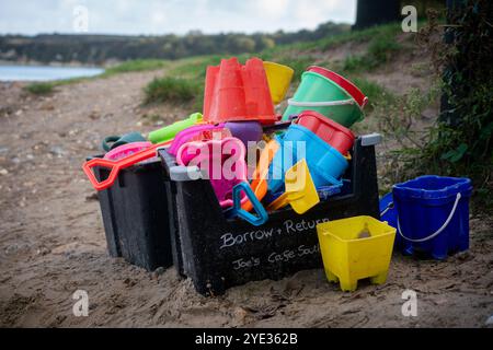 Leihen Sie sich Eimer und Pik aus und geben Sie sie zurück, um Sandburgen zu bauen, die vom örtlichen Café am Studland South Beach in Dorset, Großbritannien, hinterlassen wurden Stockfoto