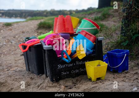 Leihen Sie sich Eimer und Pik aus und geben Sie sie zurück, um Sandburgen zu bauen, die vom örtlichen Café am Studland South Beach in Dorset, Großbritannien, hinterlassen wurden Stockfoto