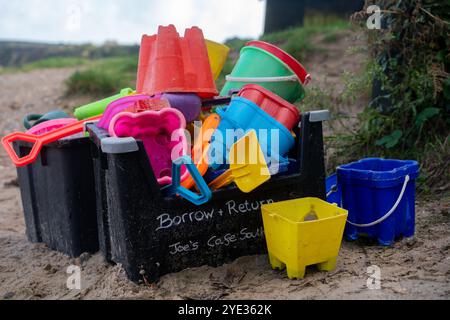 Leihen Sie sich Eimer und Pik aus und geben Sie sie zurück, um Sandburgen zu bauen, die vom örtlichen Café am Studland South Beach in Dorset, Großbritannien, hinterlassen wurden Stockfoto