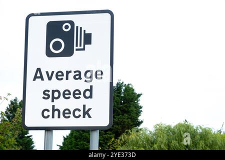 Großes Straßenschild, das den Autofahrer darauf hinweist, dass die Strecke vor der Autobahn eine Zone mit durchschnittlicher Geschwindigkeitskontrolle ist. Stockfoto