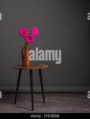 Minimalistische Einrichtung, Blumenstrauß von Gerbera in Vase auf rundem Tisch. Stockfoto