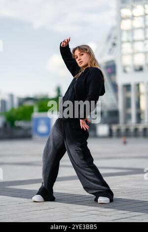 Tänzer, der bei Tageslicht in urbaner Umgebung einen Straßentanz vorführt Stockfoto