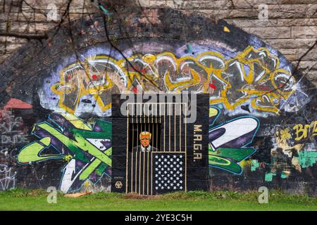 In den Gorbals, Glasgow, ist ein Street Art von Ashley Rawson zu sehen, das den republikanischen Präsidentschaftskandidaten und ehemaligen US-Präsidenten Donald Trump hinter Gittern zeigt. Die Präsidentschaftswahlen 2024 in den Vereinigten Staaten werden am Dienstag, den 5. November 2024, stattfinden. Bilddatum: Dienstag, 29. Oktober 2024. Stockfoto