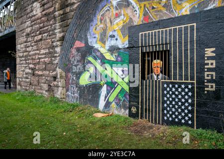 In den Gorbals, Glasgow, ist ein Street Art von Ashley Rawson zu sehen, das den republikanischen Präsidentschaftskandidaten und ehemaligen US-Präsidenten Donald Trump hinter Gittern zeigt. Die Präsidentschaftswahlen 2024 in den Vereinigten Staaten werden am Dienstag, den 5. November 2024, stattfinden. Bilddatum: Dienstag, 29. Oktober 2024. Stockfoto