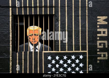 In den Gorbals, Glasgow, ist ein Street Art von Ashley Rawson zu sehen, das den republikanischen Präsidentschaftskandidaten und ehemaligen US-Präsidenten Donald Trump hinter Gittern zeigt. Die Präsidentschaftswahlen 2024 in den Vereinigten Staaten werden am Dienstag, den 5. November 2024, stattfinden. Bilddatum: Dienstag, 29. Oktober 2024. Stockfoto