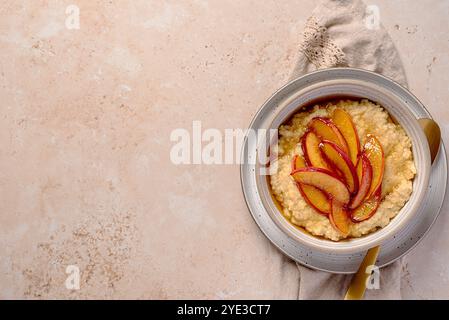 Leere Lebensmittelfotografie von Hirsebrei mit karamelisiertem Pfirsich, Nektarine mit Agavendicksaft, Honig; Kopierraum, Menü; Rezept Stockfoto