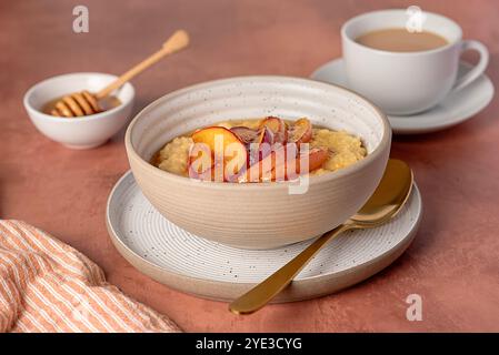 Lebensmittelfotografie von Hirsebrei mit karamelisiertem Pfirsich, Nektarine mit Agavendicksaft, Honig, Tee mit Mandelmilch Stockfoto