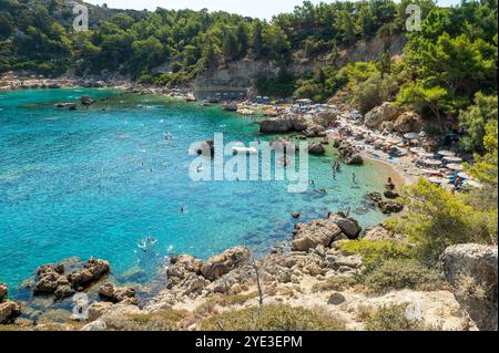 Touristen schwimmen in der Bucht von Anthony Quinn auf der Insel Rhodos in Griechenland. Dieser Strand liegt in einer der beliebtesten Buchten der Insel. Stockfoto