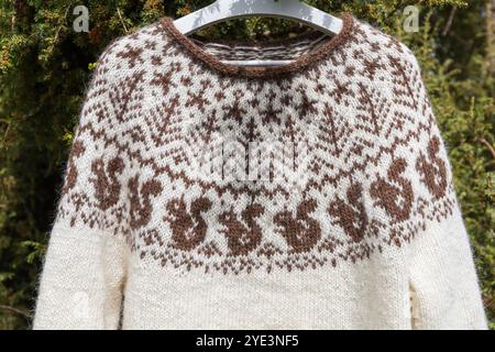 Nahaufnahme eines traditionellen isländischen Strickpullovers aus Wolle, weiß-brauner Pullover mit großer Passe im Strickmuster des nordischen Eichhörnchens Stockfoto